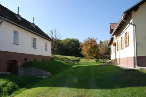 a view of the yard of a house and a building at Ruhig gelegenes Ferienhaus für erholsamen Urlaub auf dem Land inmitten der Thermenregion Sloweniens in Mala Nedelja