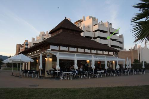 a restaurant with tables and chairs in front of a building at Bahia de la Plata in Estepona