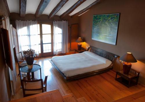 a bedroom with a bed and a table and chairs at Masia Olivera in Sant Pau dʼOrdal