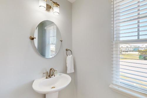 a white bathroom with a sink and a mirror at Whelk #22B-CAC in Buxton