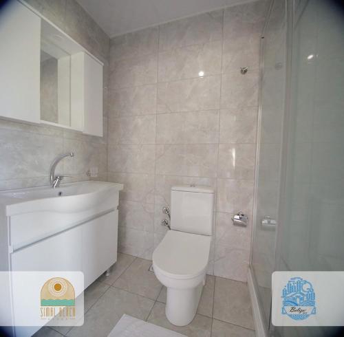 a bathroom with a toilet and a sink and a shower at Belize suit otel in Muğla