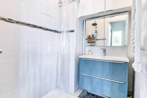 bagno con lavandino blu e doccia di Appartement Love près des Grands Magasins - 6P a Parigi