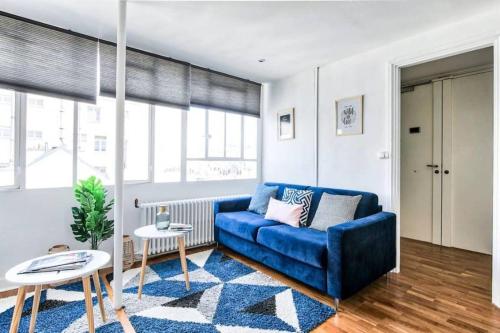 un salon avec un canapé bleu et une table dans l'établissement Appartement Love près des Grands Magasins - 6P, à Paris