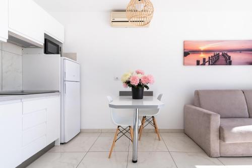 a kitchen with a chair and a table with flowers at Mariposa Del Sol in Patalavaca