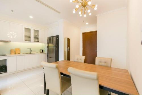 une grande cuisine avec une table et des chaises en bois dans l'établissement Vinhomes Apartment, à Hô-Chi-Minh-Ville