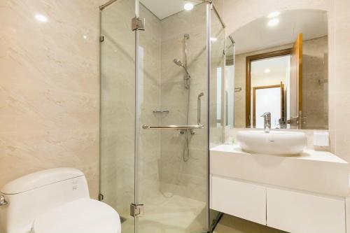 La salle de bains est pourvue d'une douche, de toilettes et d'un lavabo. dans l'établissement Vinhomes Apartment, à Hô-Chi-Minh-Ville