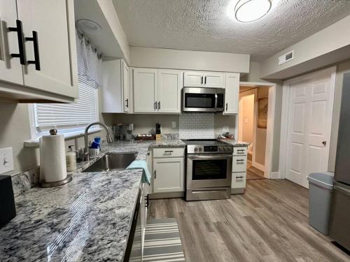 une cuisine avec des armoires blanches et des appareils en acier inoxydable dans l'établissement 3 Bedroom Home, Walk to Lake Erie, à Willoughby