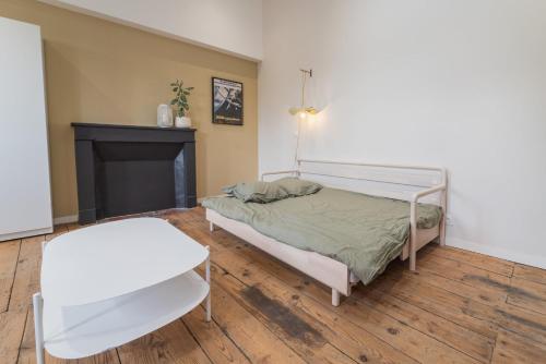 um quarto com uma cama, uma mesa e uma cadeira em Le Nid em Poitiers