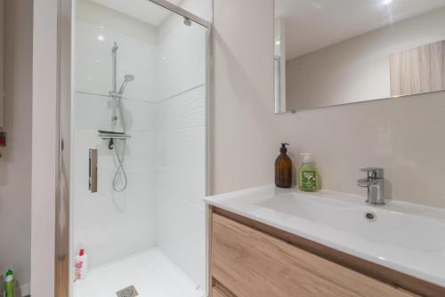 uma casa de banho com um lavatório branco e um chuveiro em Le Nid em Poitiers