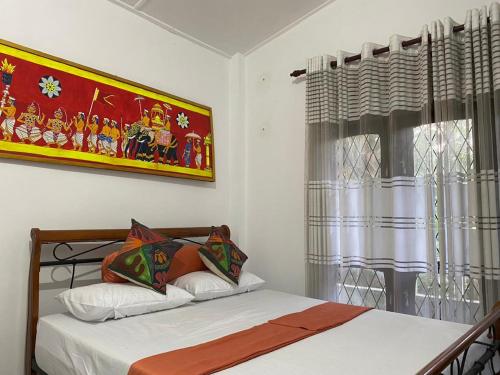 a bedroom with a bed and a picture on the wall at Richland's Villa in Kandy