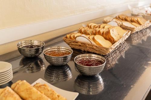 a table topped with baskets of bread and bowls of dips at Hôtel de la Mairie in Saint-Pol-de-Léon