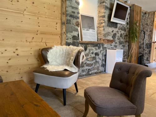 a living room with a chair and a table at LA FERME DU FAY in Sixt