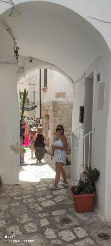 a woman standing under an archway in a building at Petali Rosa- Dimora Grottino in Polignano a Mare