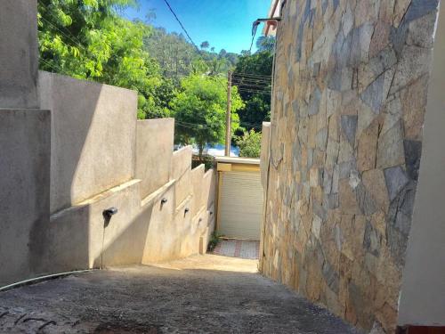 an alley with a stone wall and a garage at Lucky Home Kandy in Ampitiya