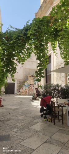 a courtyard with tables and chairs and a building at Petali Rosa- Dimora Grottino in Polignano a Mare
