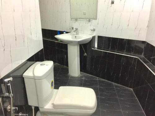 a bathroom with a white toilet and a sink at Lucky Home Kandy in Ampitiya