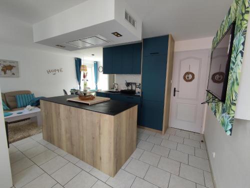 une cuisine avec des armoires bleues et un comptoir dans l'établissement Charmes et chic, à Charmes
