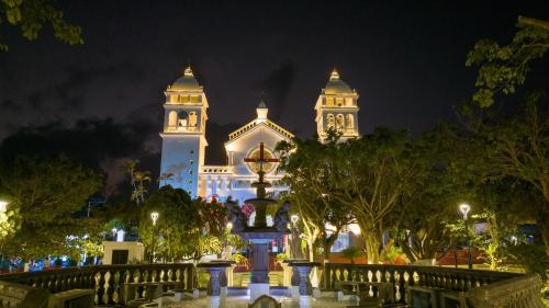 a building with a fountain in front of it at night at Orquídea Loft in Juayúa