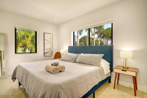 1 dormitorio con 1 cama grande con 2 troncos en Luxe Pool - FirePit - Walk 2 Brickell Dining &Bars, en Miami