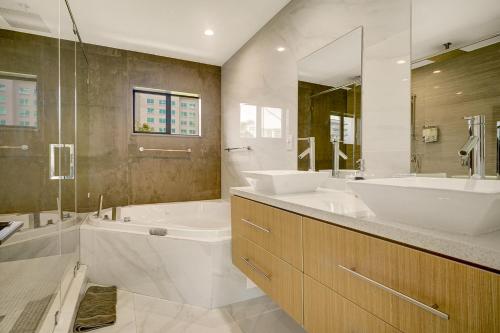 uma casa de banho com 2 lavatórios, uma banheira e um chuveiro em Luxe Pool - FirePit - Walk 2 Brickell Dining &Bars em Miami