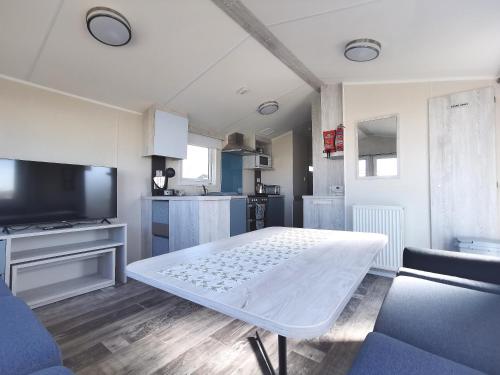 a living room with a white table and a tv at Sea activities Golden Sands beach relax in Mablethorpe