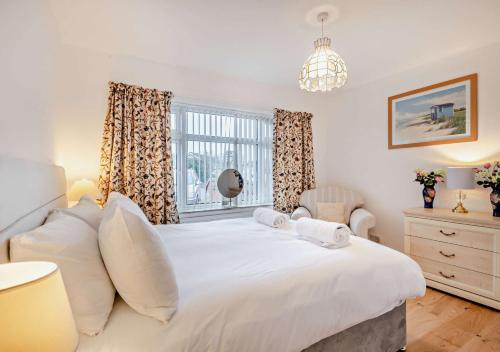 a bedroom with a large white bed and a window at Sunbeam in Snettisham