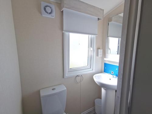 a bathroom with a toilet and a sink and a window at Sea activities Golden Sands beach relax in Mablethorpe