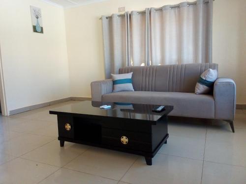 een woonkamer met een bank en een salontafel bij Kulu Lodge Apartments in Lusaka