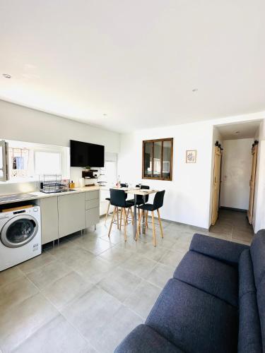 un salon avec un canapé bleu et une cuisine dans l'établissement P’tit bonheur, au Grau-dʼAgde