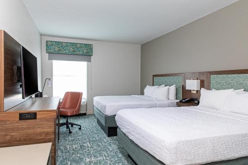 a hotel room with two beds and a desk at Hampton Inn & Suites Charleston-West Ashley in Charleston
