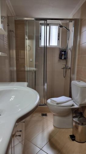 uma casa de banho com um lavatório, um WC e um chuveiro em Be Our Guest em Lepanto