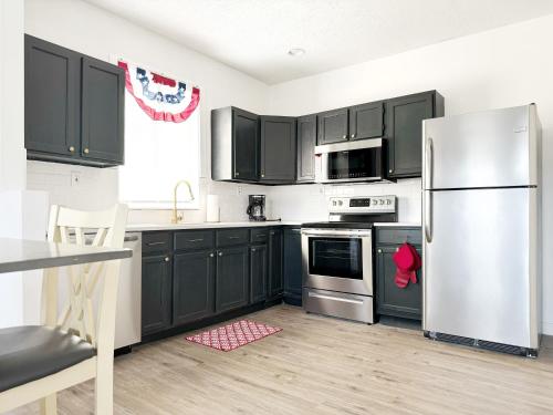 a kitchen with black cabinets and a stainless steel refrigerator at Evansville Holiday House in Evansville