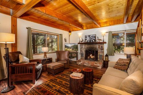 a living room with a couch and a fireplace at Arrowhead Pine Rose Cabins in Twin Peaks