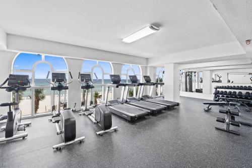 a gym with treadmills and chairs in a building at Calypso Resort by Panhandle Getaways in Panama City Beach