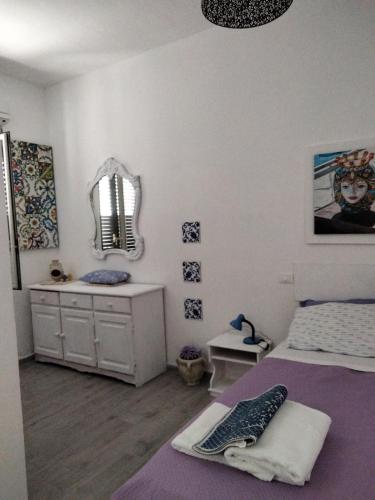 Schlafzimmer mit einem Bett, einem Schreibtisch und einem Spiegel in der Unterkunft Casetta Blu Mondello zona Partanna in Palermo