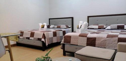 dos camas sentadas una al lado de la otra en una habitación en J & F Homestay - Cavite, Philippines, en Trece Martires