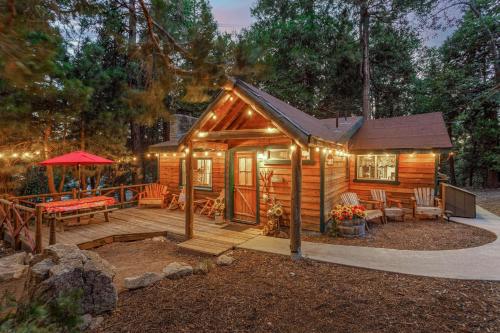 a cabin in the woods with a deck and a patio at Arrowhead Pine Rose Cabins in Twin Peaks