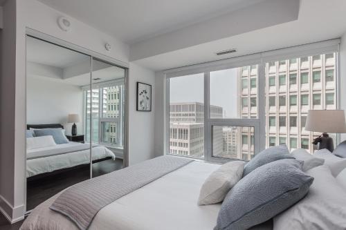 a bedroom with two beds and a large window at Luxury Condo on Bay Street in Toronto