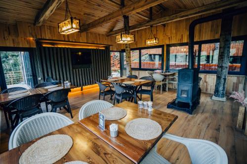 a restaurant with tables and chairs and a wood stove at Montana Suite Bungalows in Trabzon