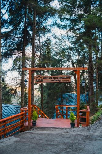 a wooden gate with a sign in a park at Montana Suite Bungalows in Trabzon