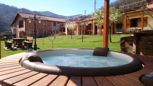 a hot tub sitting on a deck in a yard at Apartamentos Rurales Balcón Real Senda del Oso in Campiello