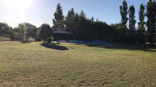 een groot grasveld met een huis op de achtergrond bij Quinta Los Patos in Toay