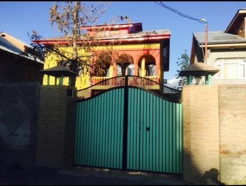 a green gate in front of a house at KaShMiR ViBeS HoMeStAy Family Room in Srinagar