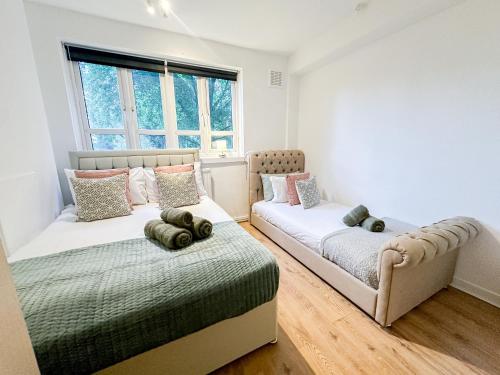 a bedroom with two beds and a couch at Vibrant 3BR flat near Finsbury Park in London