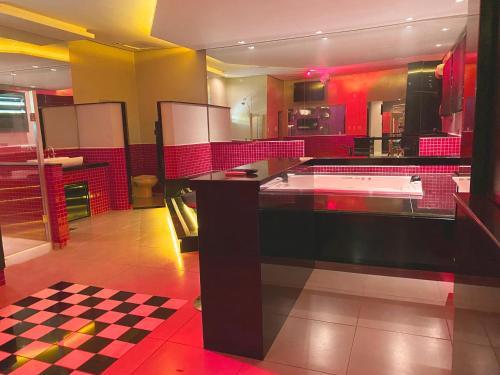 Genuino Sampaio的住宿－Motel Baviera，一间铺有 ⁇ 制地板和红色墙壁的大厨房