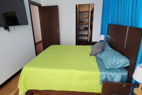 a bedroom with a bed with a green comforter at Hermoso departamento sobre Av. America cerca al Sombrero de Chola in Cochabamba