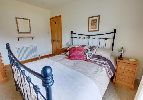 a bedroom with a large bed with two pillows on it at Avocet Cottage in Dersingham