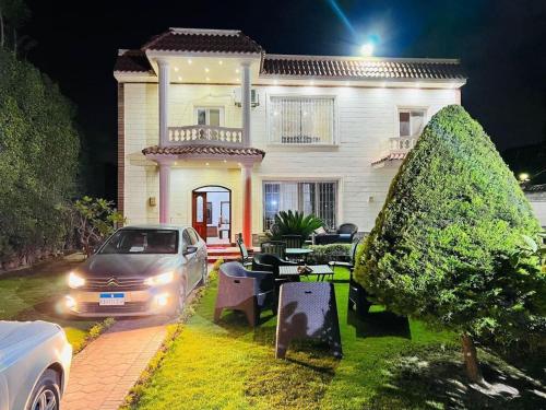a car parked in front of a house at night at private Villa with a special view in Qaryat Shākūsh
