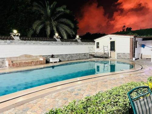 a swimming pool in front of a house at night at private Villa with a special view in Qaryat Shākūsh