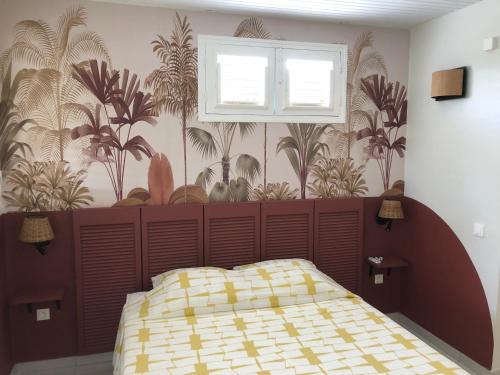 sypialnia z łóżkiem ze ścianą z roślinami w obiekcie Villa Diamant Bleu w mieście Le Diamant